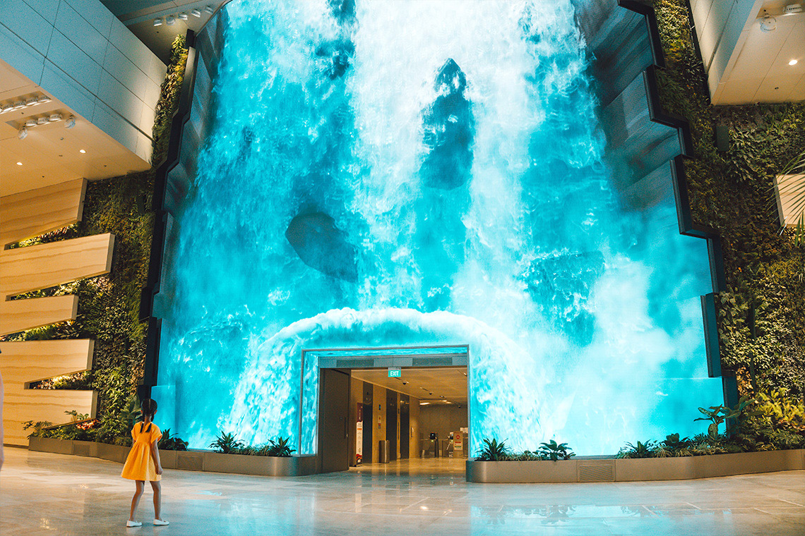 Nikmati keindahan The Wonderfall, air terjun digital di Terminal 2 Changi Airport.
